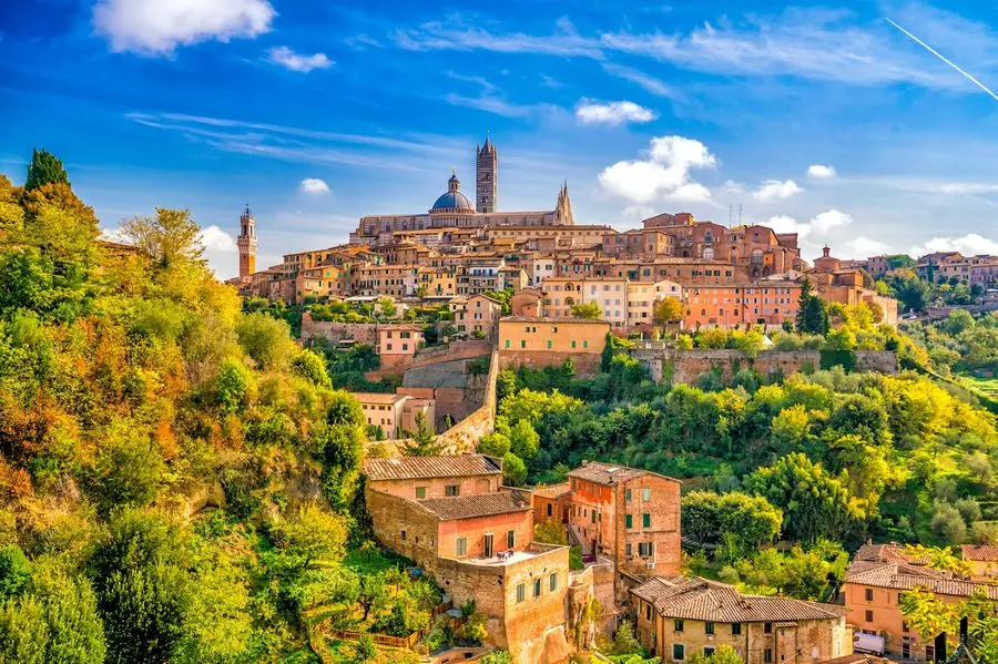 Siena's skyline with the striped Duomo bell tower at golden hour