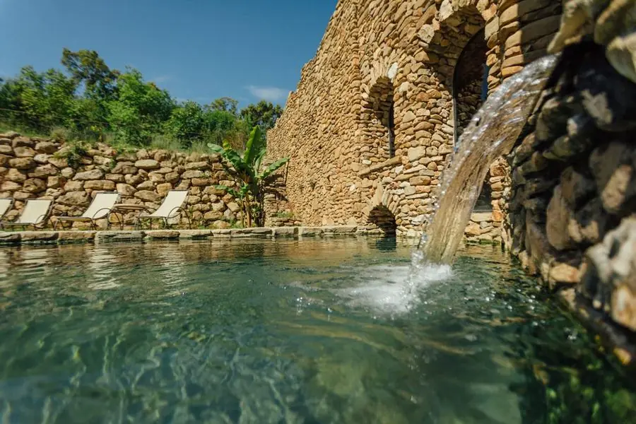 Natural stone thermal pools surrounded by greenery