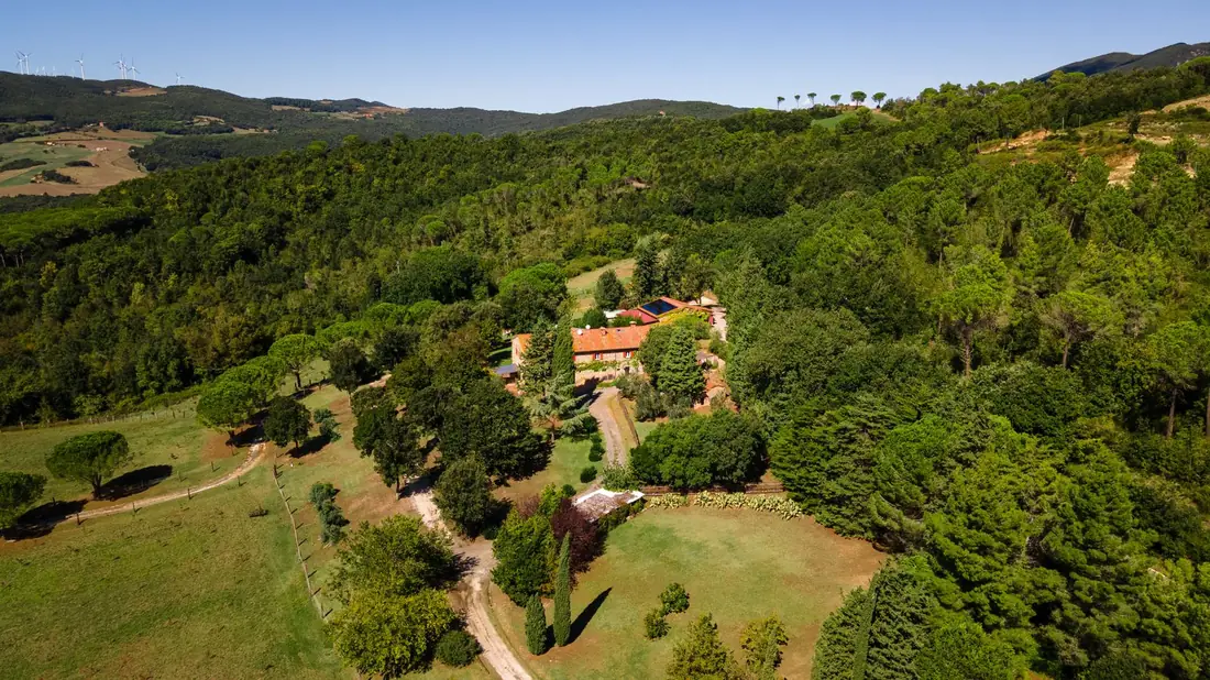 Villa Fonteintanata seen from above, tucked into the wooded hills of the Val di Cecina